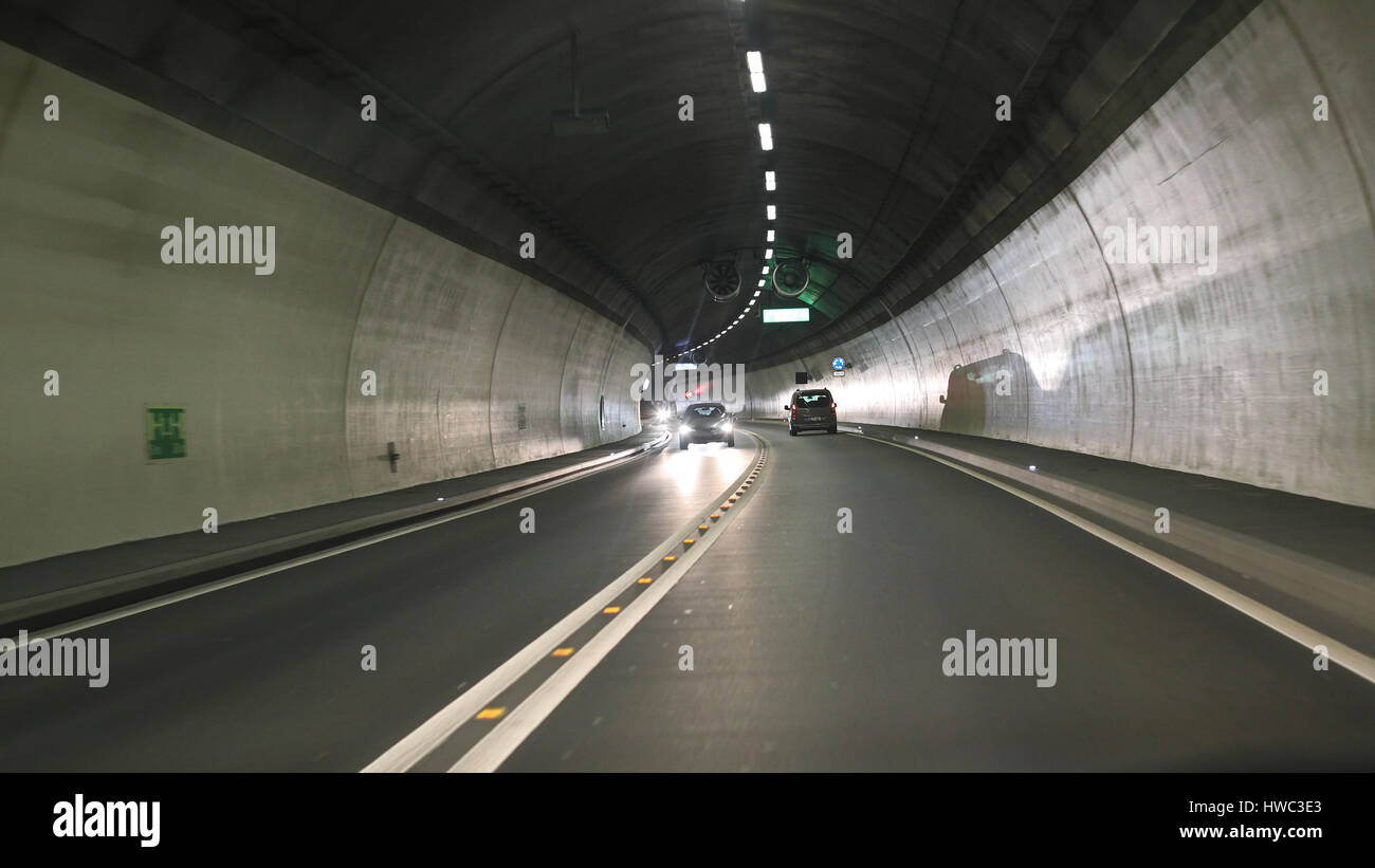 Light and projected shadows inside the Vedeggio-Cassarate road tunnel with lights,signs and traffic Stock Photo