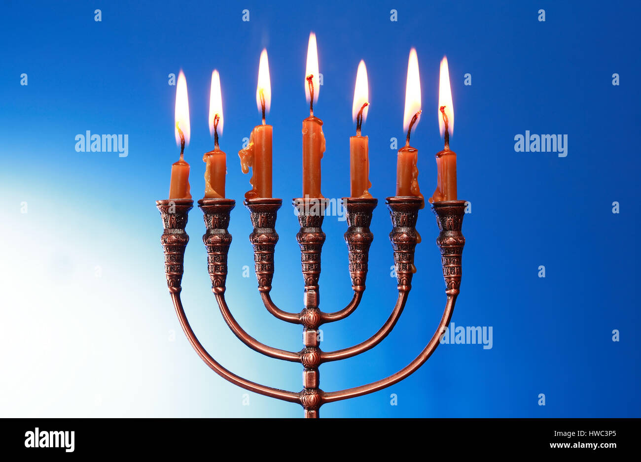 Traditional jewish menorah with lighting candles on nice blue
