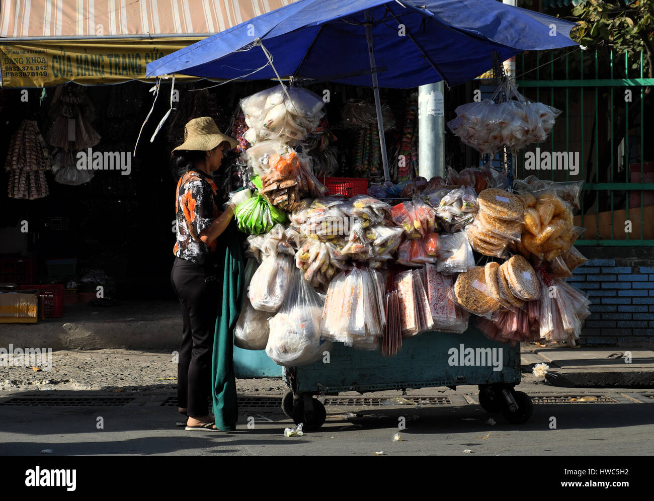 HO CHI MINH CITY, VIET NAM- MARCH 18, 2017: Vietnamese street food at Cho Lon market, street vendor earn money with many kind of rice paper in push ca Stock Photo