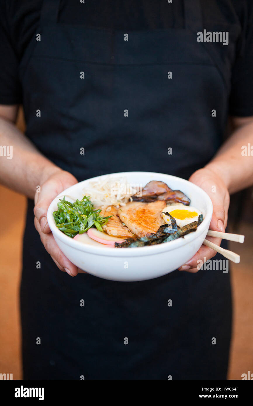 Chef holding ramen noodle bowl at an Asian restaurant Stock Photo