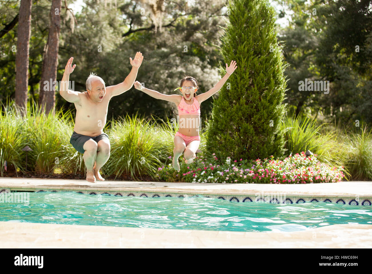 Grandfather swims in the pool with his grandaughter Stock Photo