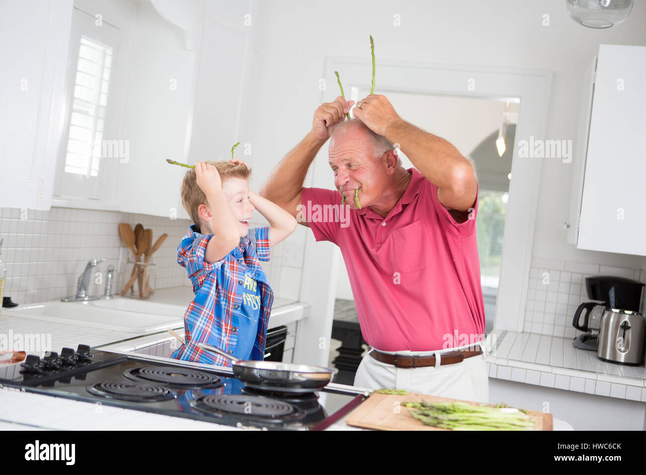Grandfather and boy playing in kitchen Stock Photo