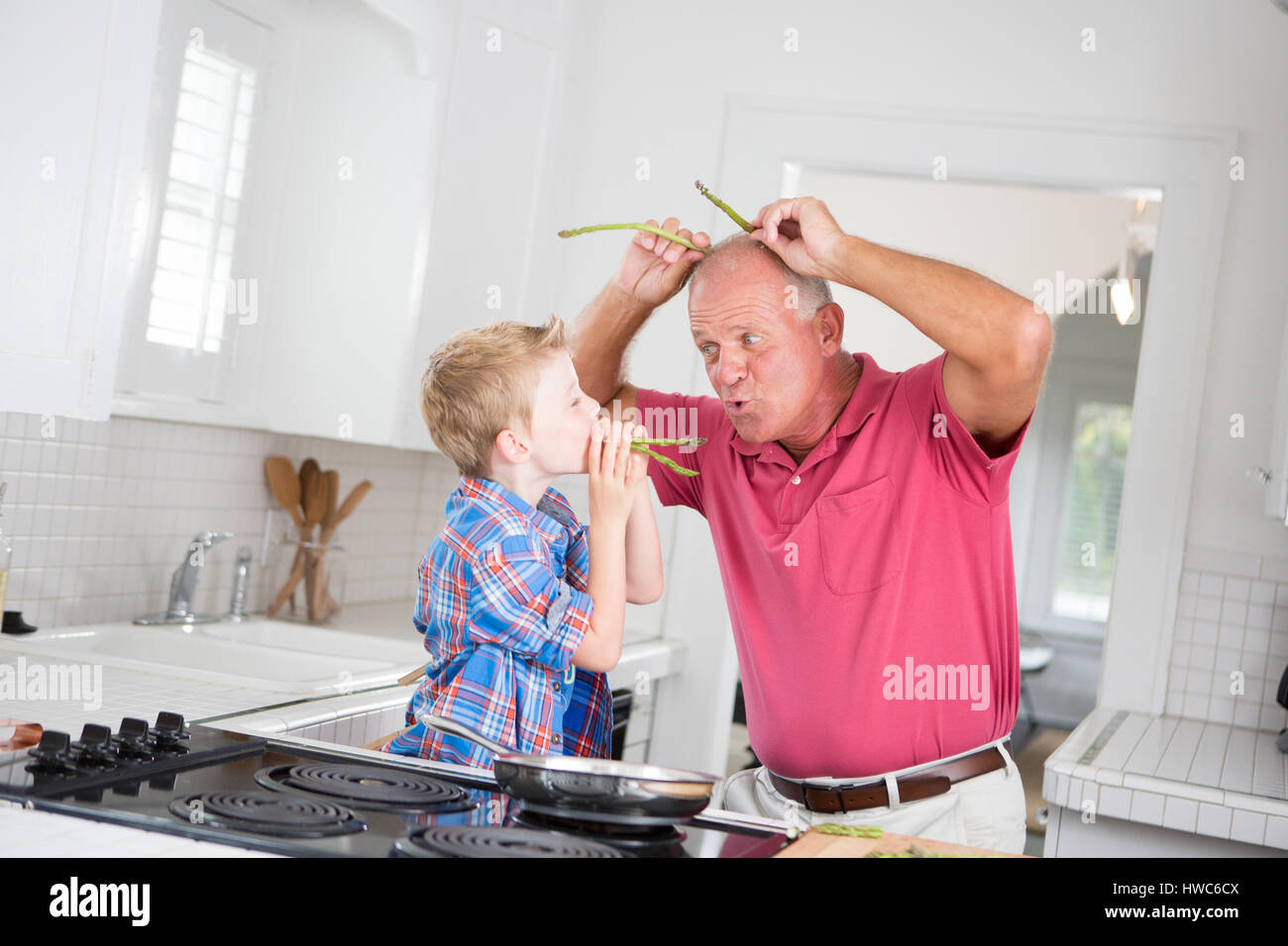 Grandfather and boy playing in kitchen Stock Photo