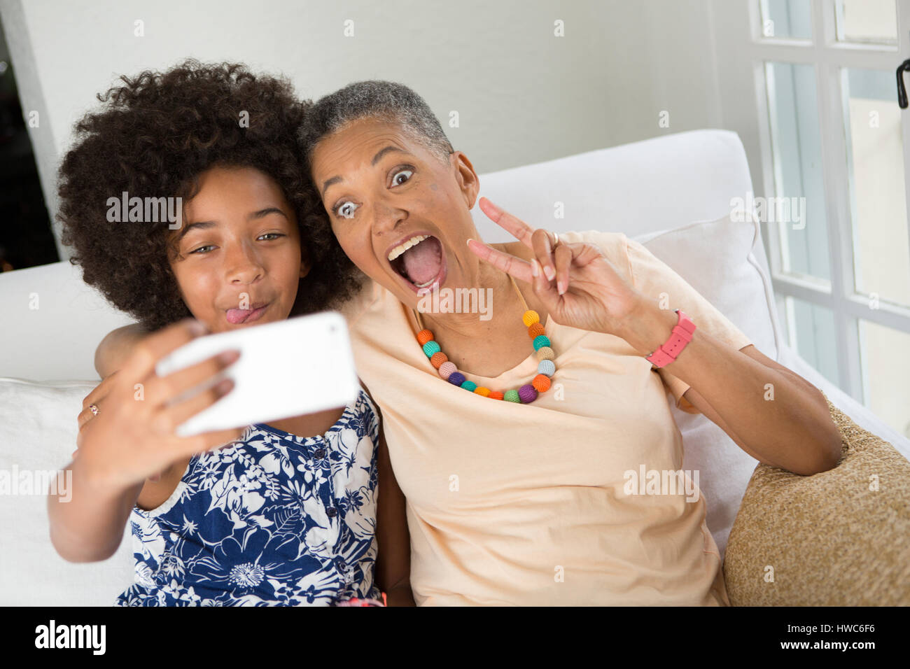 Girl teaching grandmother how to take a selfie Stock Photo