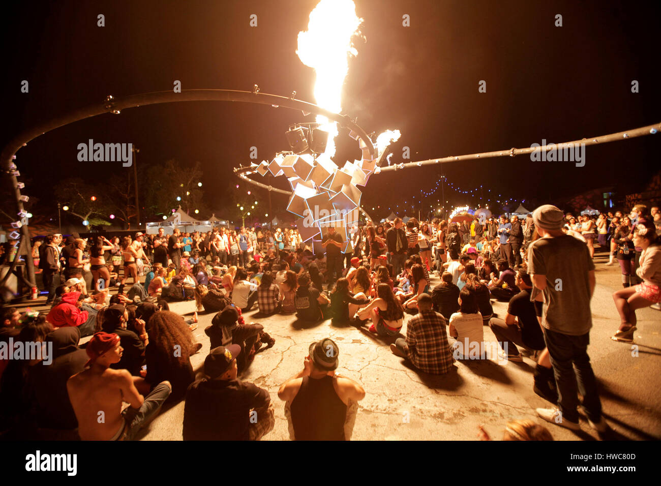 Fans gather around an fire spewing art installation at the Beyond ...