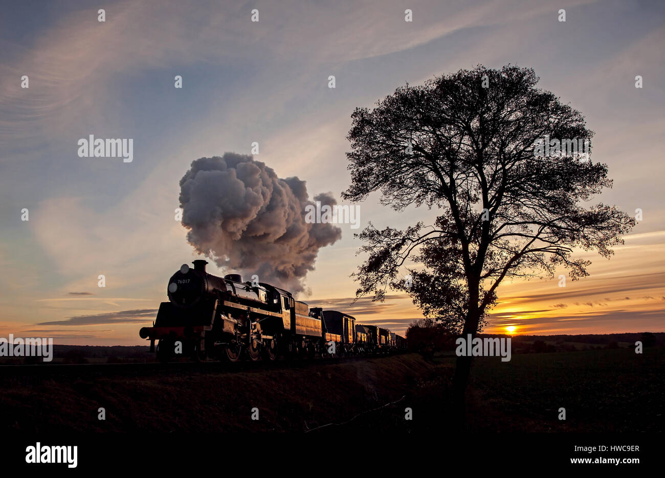 Newly restored Standard No. 76017 is seen on a Matt/Warwick photo charter at the Mid Hants Railway on 13 November 2016. As the sun heads for the horiz Stock Photo