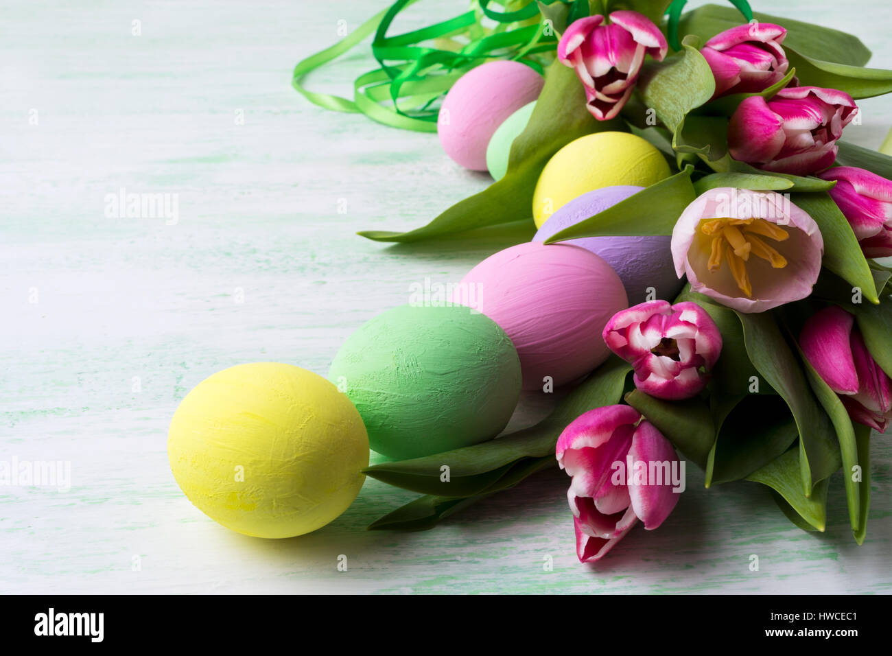 Easter table centerpiece with pink tulips and pale color painted eggs ...