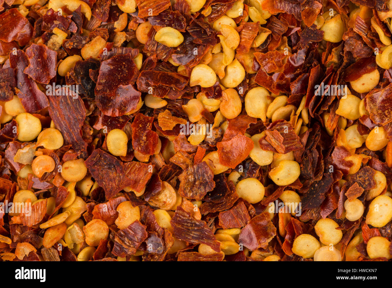 The pile of a crushed red pepper, dried chili flakes and seeds as a background Stock Photo Alamy