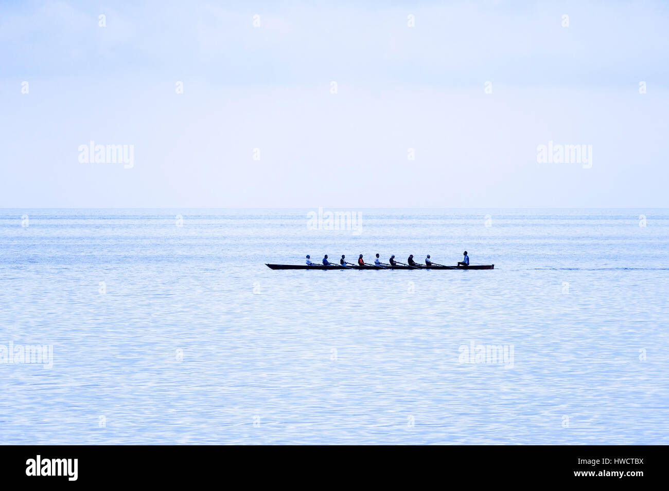 An oar boat with eight rowers and coxswain by the sea, Ein Ruderboot mit acht Ruderern und Steuermann am Meer Stock Photo