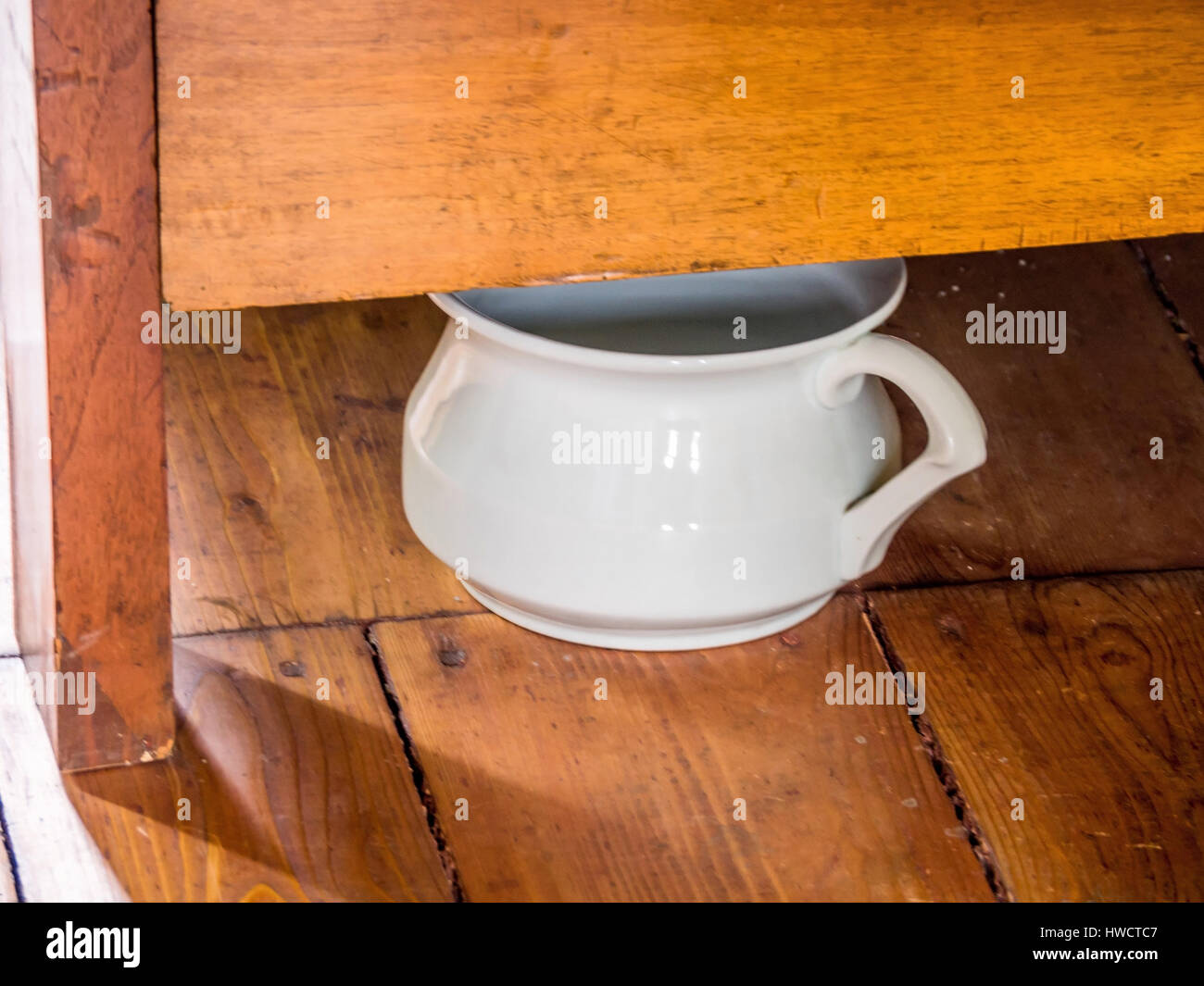 Under a bed the chamber pot stands for all cases., Unter einem Bett steht der Nachttopf für alle Fälle. Stock Photo