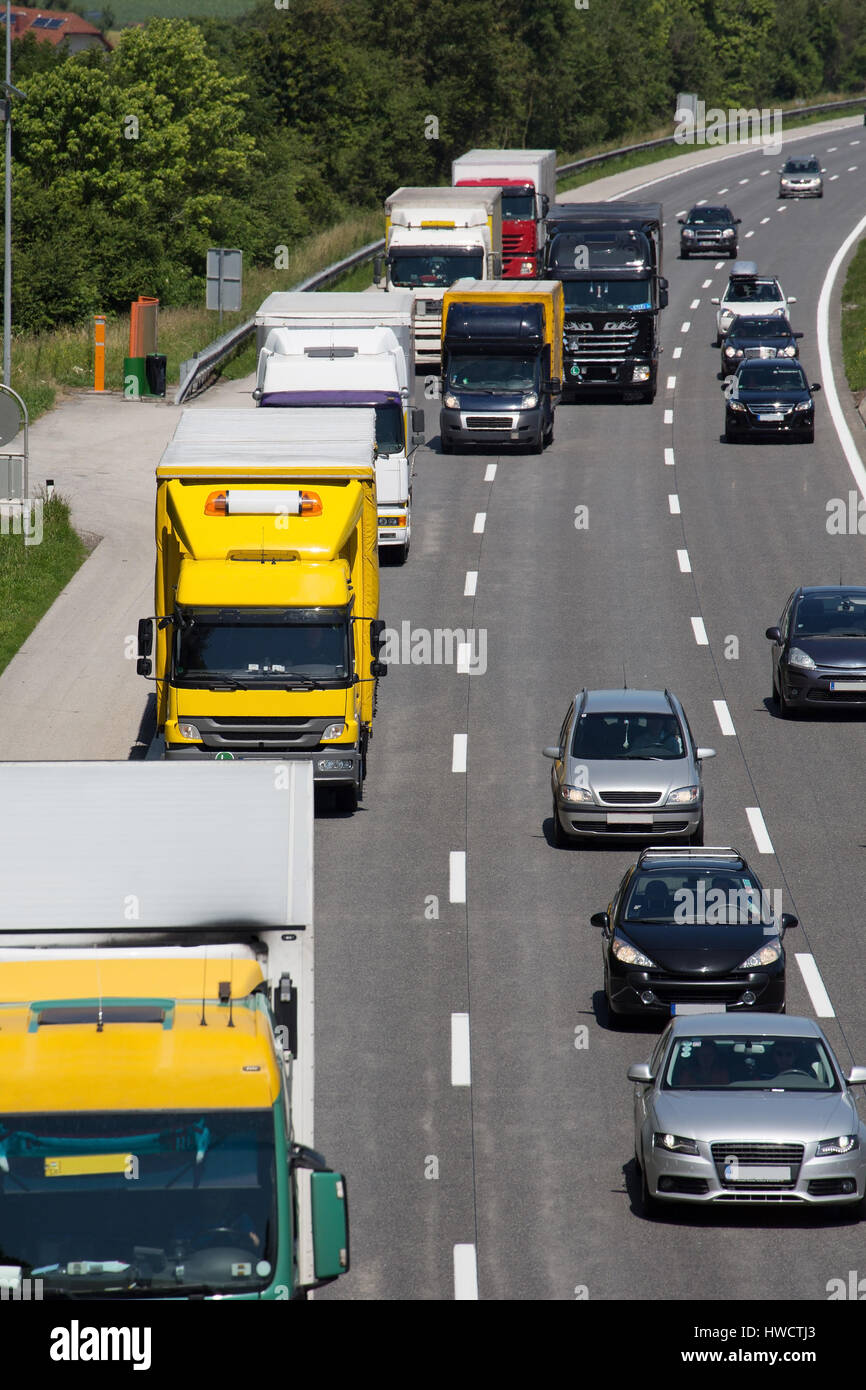 Trucks on a three-lane highway. Symbolic photo for transportation of goods, Lastwagen auf einer dreispurigen Autobahn. Symbolfoto für Beförderung von  Stock Photo