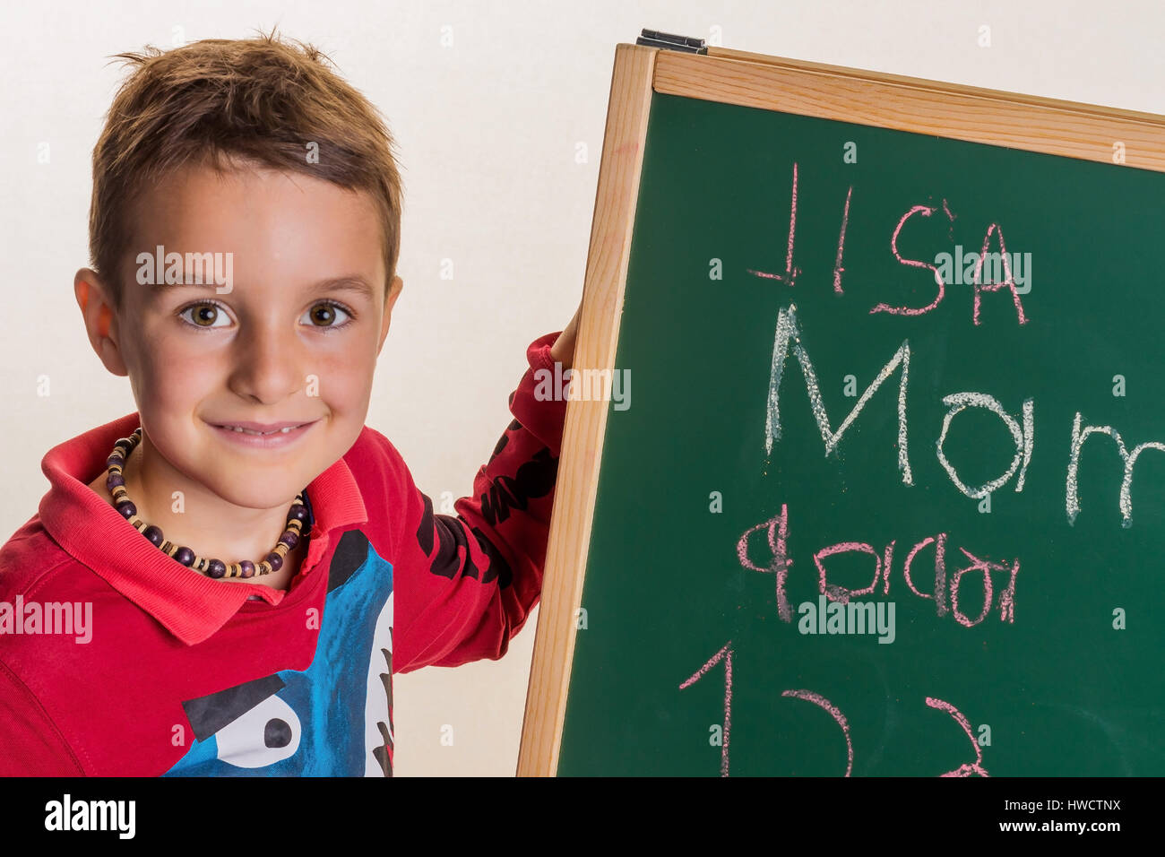 'A child writes the word ''mummy'' on a school board', Ein Kind schreibt das Wort ' Mama ' auf eine Schultafel Stock Photo