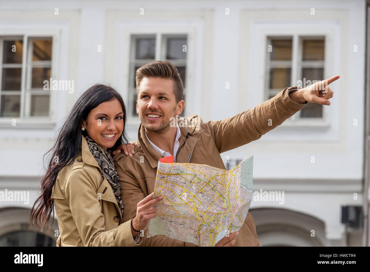Young pair with town plan and guide with the inspection of a town on vacation, Junges Paar mit Stadtplan und Reiseführer bei der Besichtigung einer St Stock Photo