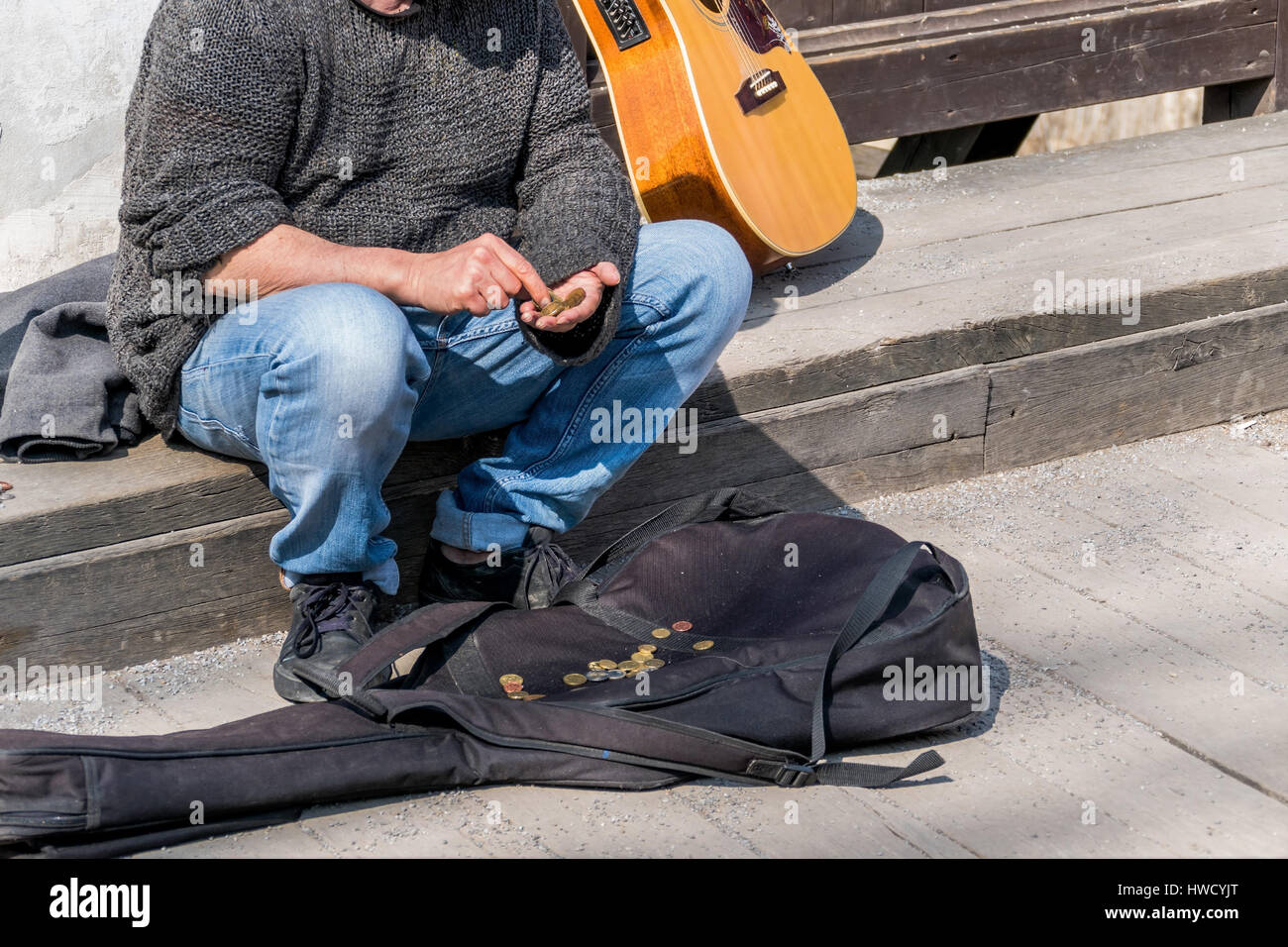 A street musician counts his income. survive as an artist, Ein Strassenmusiker zählt seine Einnahmen. Überleben als Künstler Stock Photo