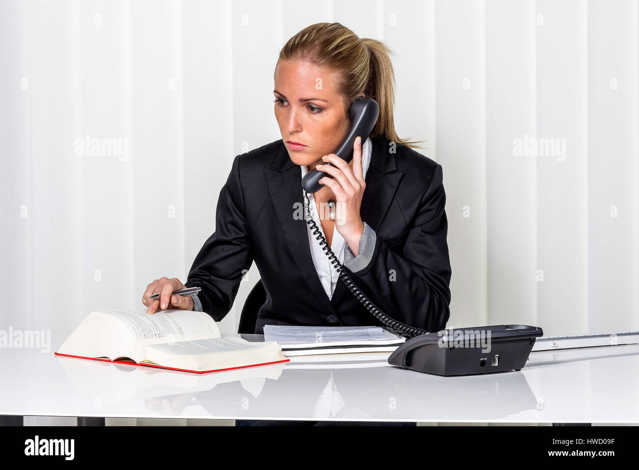 Businesswoman sits in an office. Symbolic photo for managers, independency or lawyer., Geschaeftsfrau sitzt in einem Buero. Symbolfoto fuer Manager, S Stock Photo