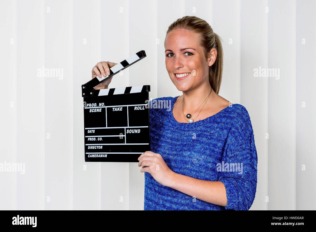 A woman shuts a typical film mouth in her hand, Eine Frau h‰lt eine typische Filmklappe in ihrer Hand Stock Photo