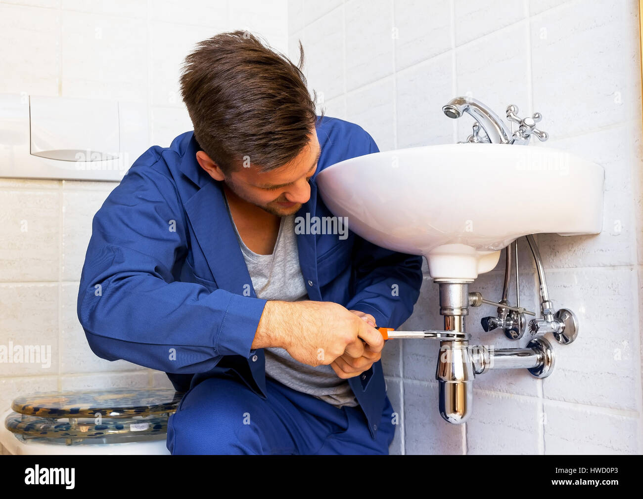 A plumber (Insatallateur) at the work, Ein Klemptner ( Insatallateur ) bei der Arbeit Stock Photo