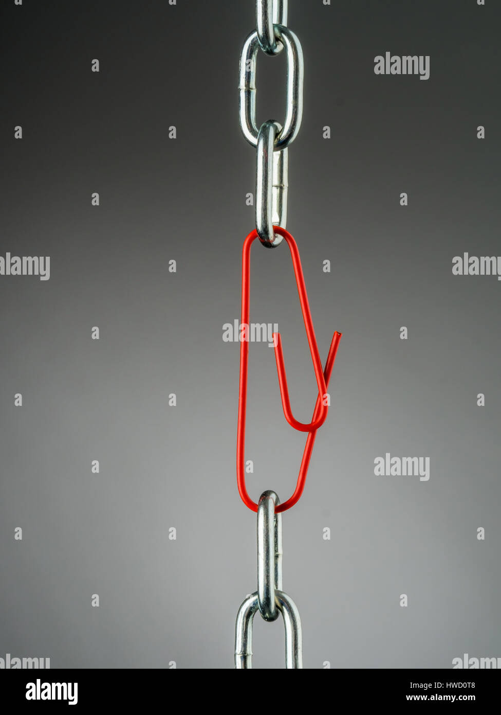 A chain is held together with a B?rokklammer. Symbolic photo for security, trust and Teamwork, Eine Kette wird mit einer Bürokklammer zusammen gehalte Stock Photo