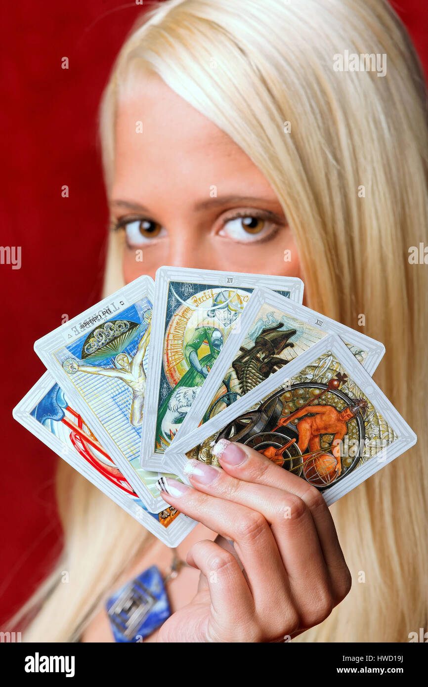 Young woman interprets the future from tarot maps in her hands, Junge Frau deutet die Zukunft aus Tarotkarten in ihren H‰nden Stock Photo