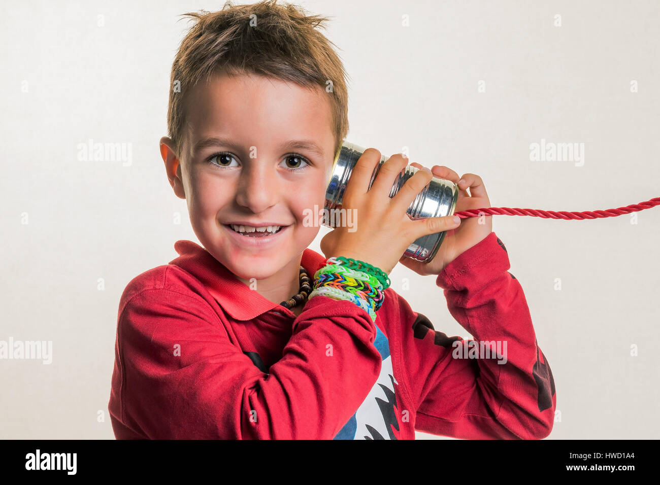 Child listens in a canned phone., Kind horcht in ein Dosentelefon. Stock Photo