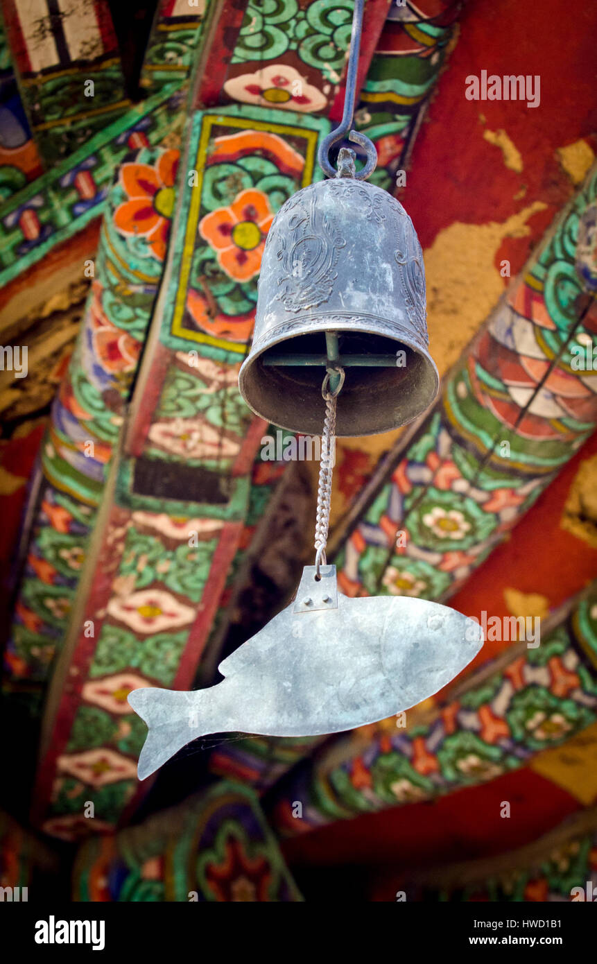 A metal windchime hangs from a Korean Buddhist Temple Stock Photo