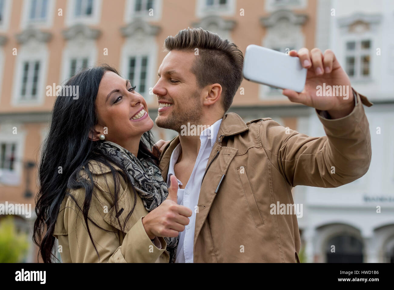 A young pair makes a selfportrait with a mobile phone. Selfies are in., Ein junges Paar macht ein Selbstporträt mit einem Handy. Selfies sind in. Stock Photo