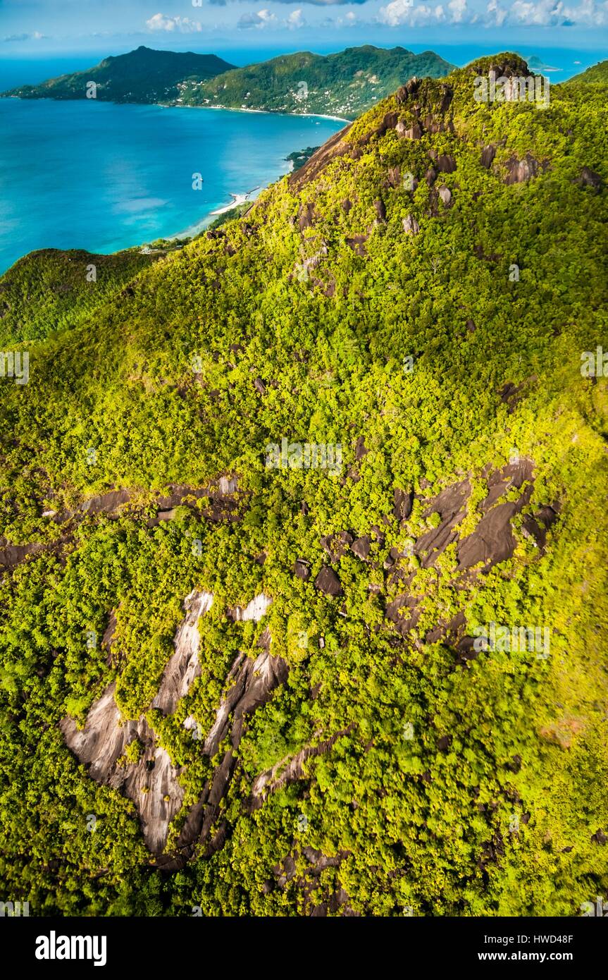 Seychelles, Mahe island, the rainforest and granite cliffs of the Morne Seychellois National Park with the villages of Bel Ombre and Beau Vallon in the background (aerial view) Stock Photo