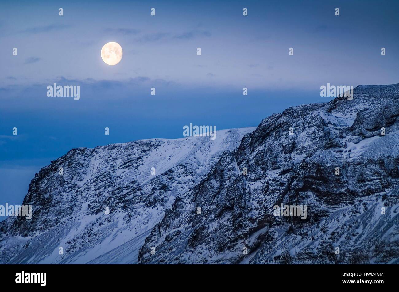 Iceland, mid-day moonlight in the Arctic winter over snow-covered mountains Stock Photo