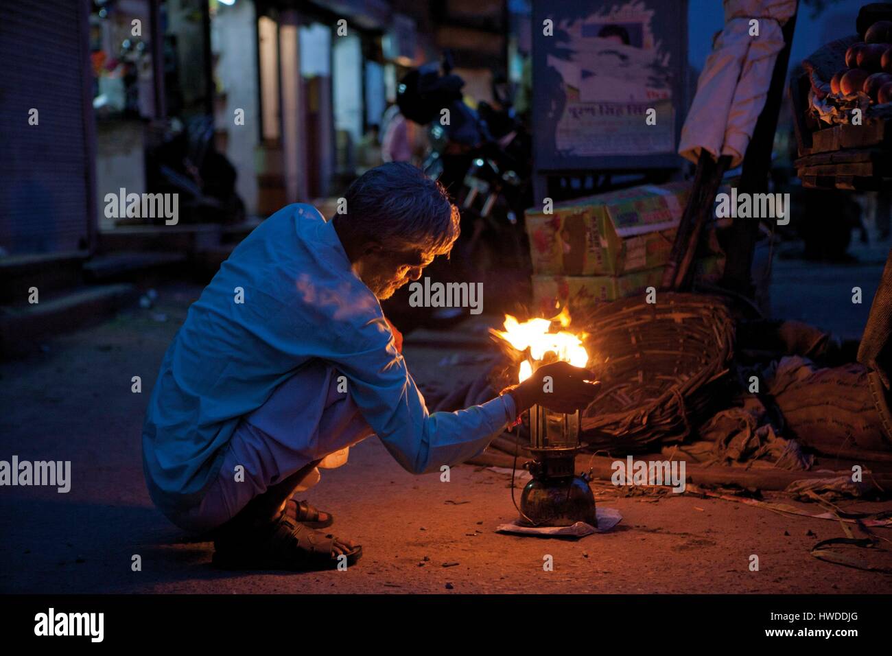India, Rajasthan, Jaipur, man lighting a storm lamp in the street Stock