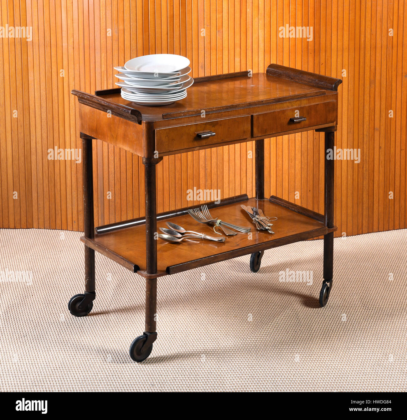 Vintage wooden server table or trolley with two drawers on wheels for  serving food at a dining table with cutlery and stacked dishes Stock Photo  - Alamy