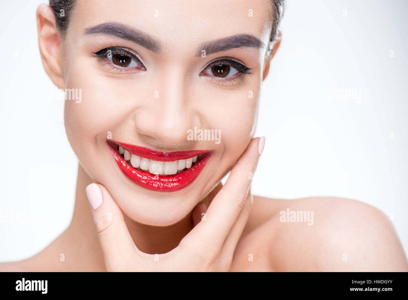 Portrait of beautiful woman with juicy red lips touching face by hand Stock Photo