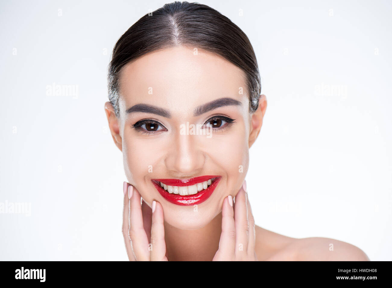 Portrait of female with juicy red lips touching face by hands isolated on white Stock Photo