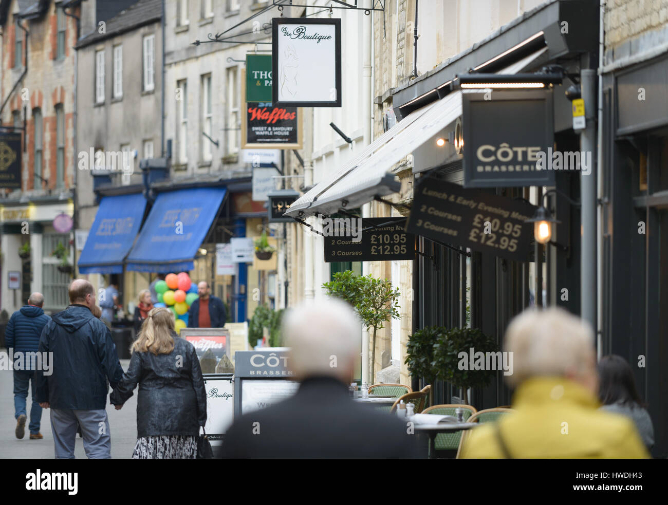 People walk down Black Jack Street, Cirencester in the Cotswolds, Gloucester, England, UK Stock Photo