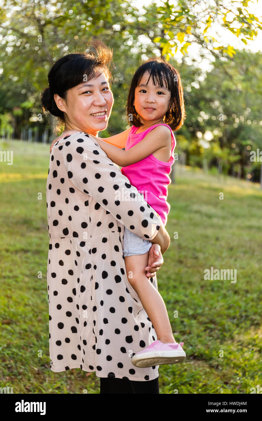 Asian Chinese Mother Hugging Daughter At The Park in the evening Stock