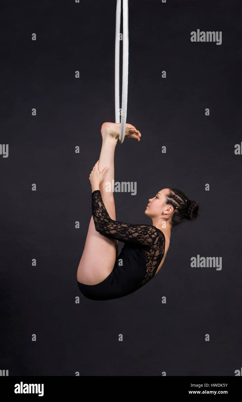 Aerial acrobat in the ring. A young woman performs the acrobatic ...