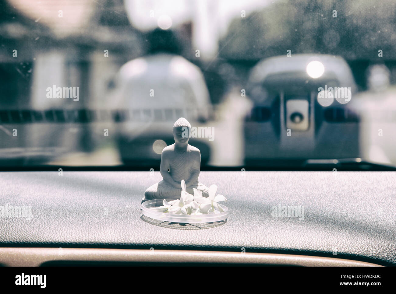 Small Buddha figurine in the front window of a car - as protection and safety in traffic, Weligama, Sri Lanka. Stock Photo