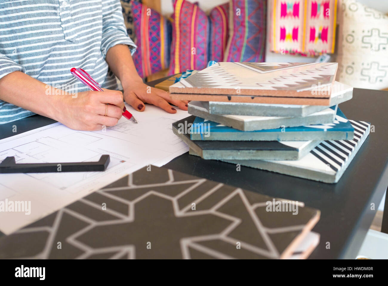 Mid section of female interior designer drawing designs at desk in retail studio Stock Photo