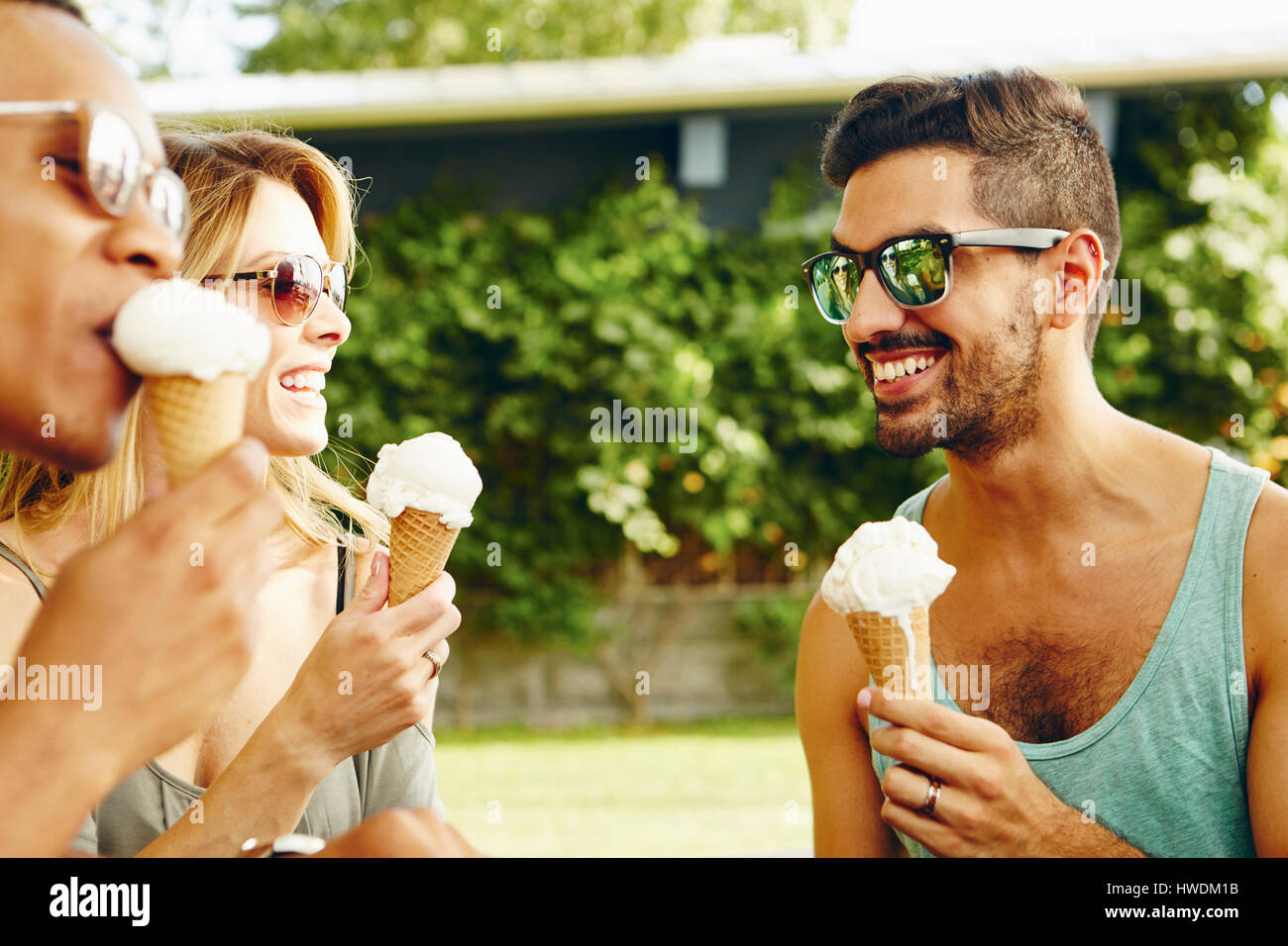 Male and female friends eating ice cream cones in park Stock Photo