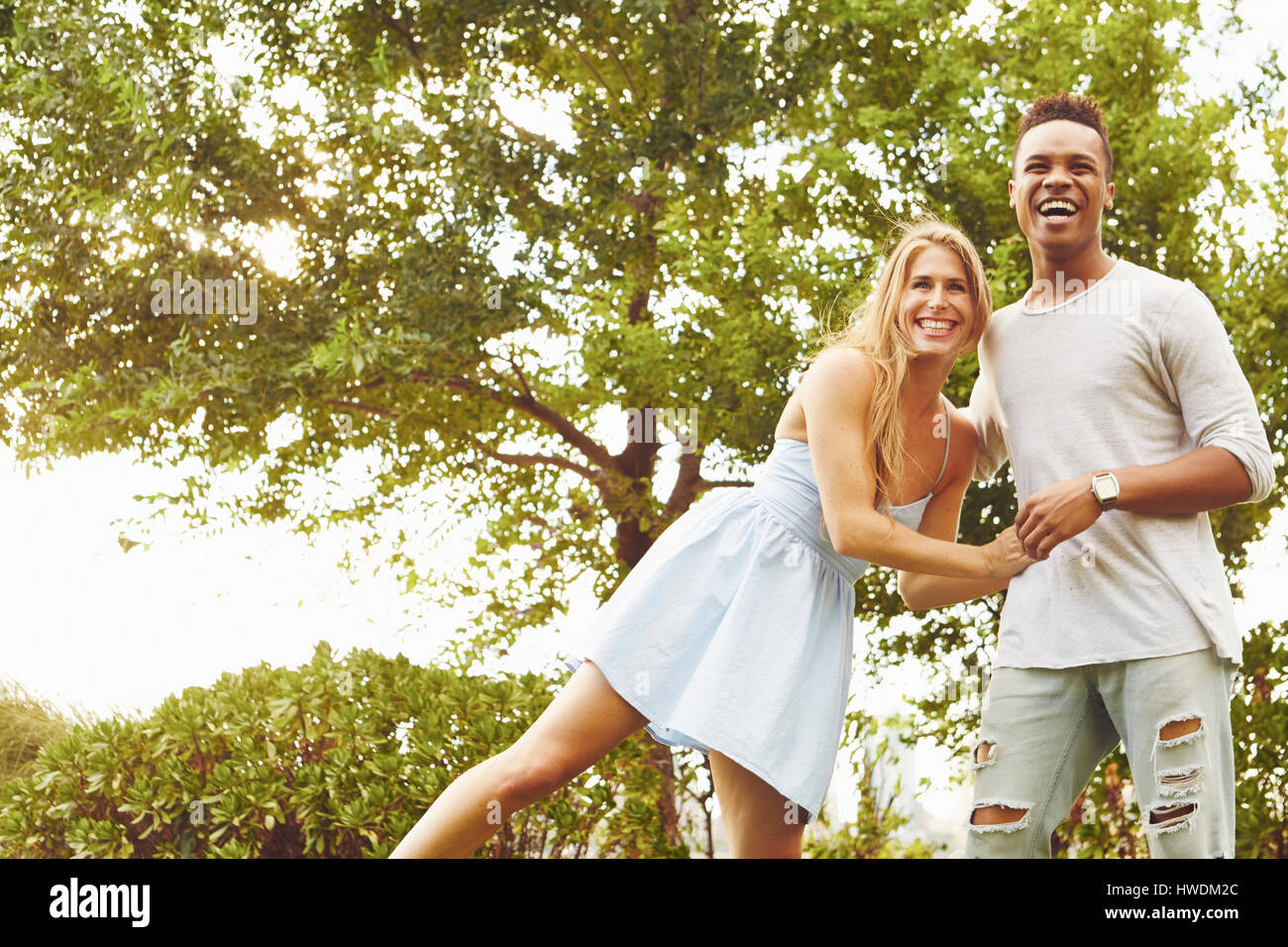 Young woman and man laughing together in park Stock Photo - Alamy