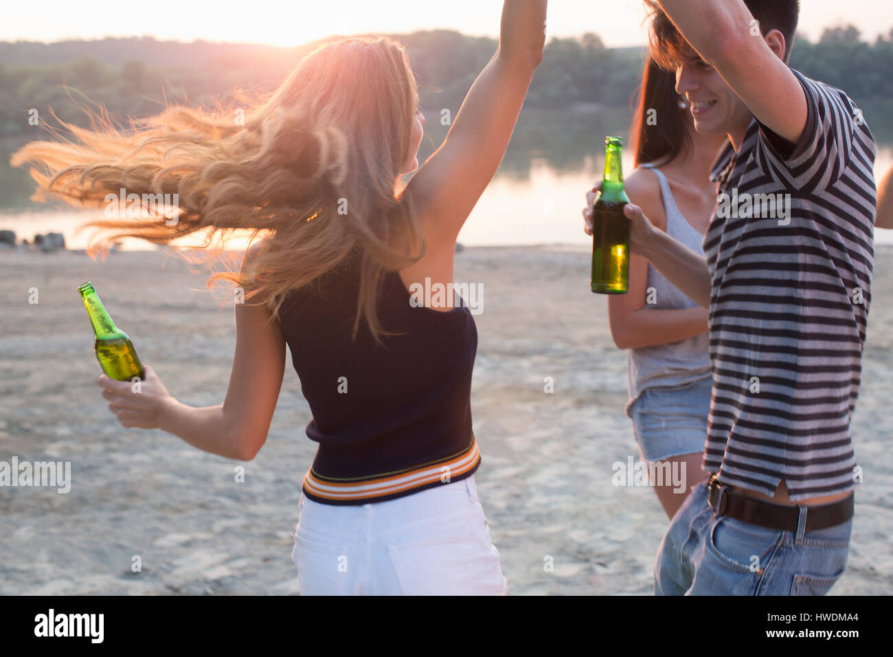 Group of friends drinking, enjoying beach party Stock Photo