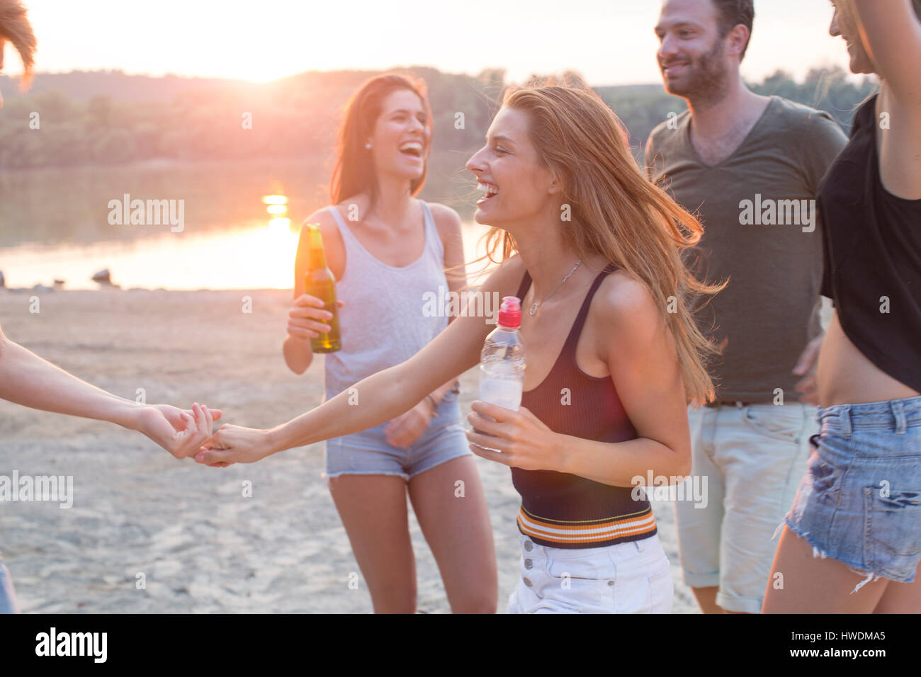 Group of friends drinking, enjoying beach party Stock Photo