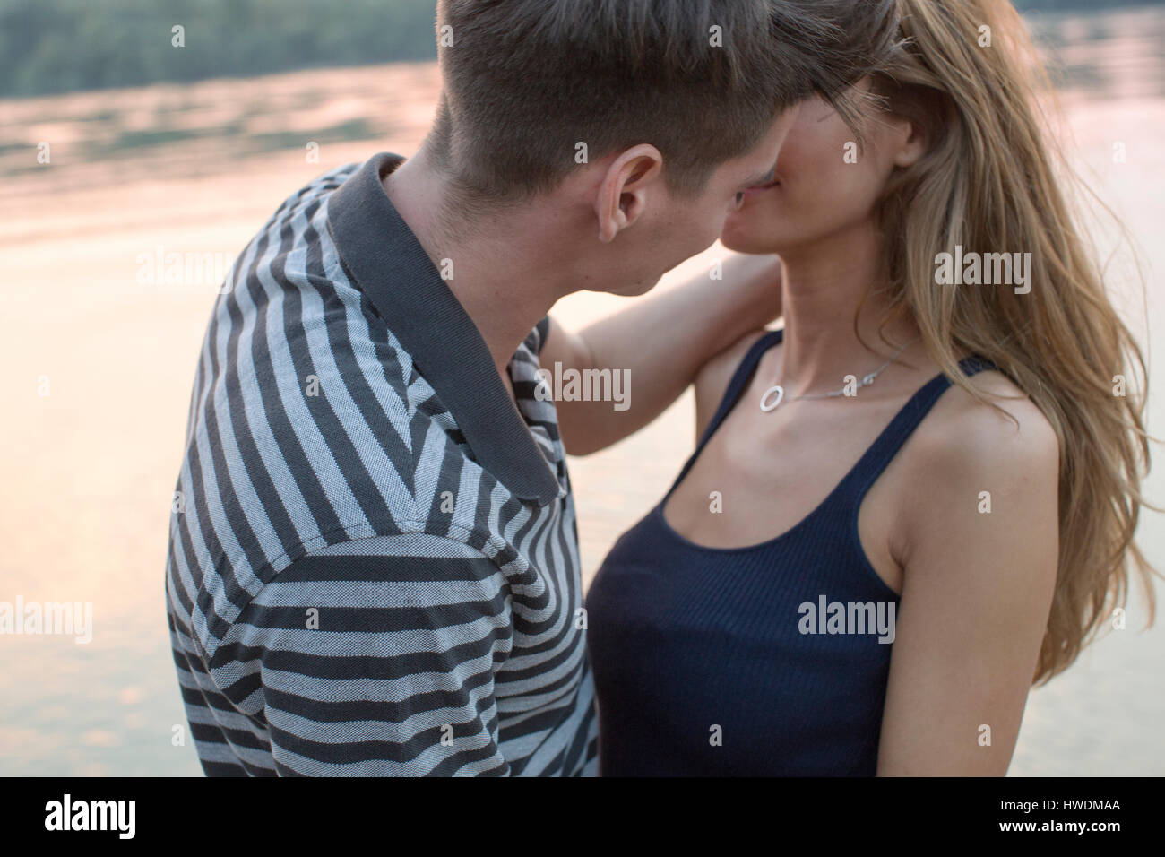 Couple kissing by river Stock Photo