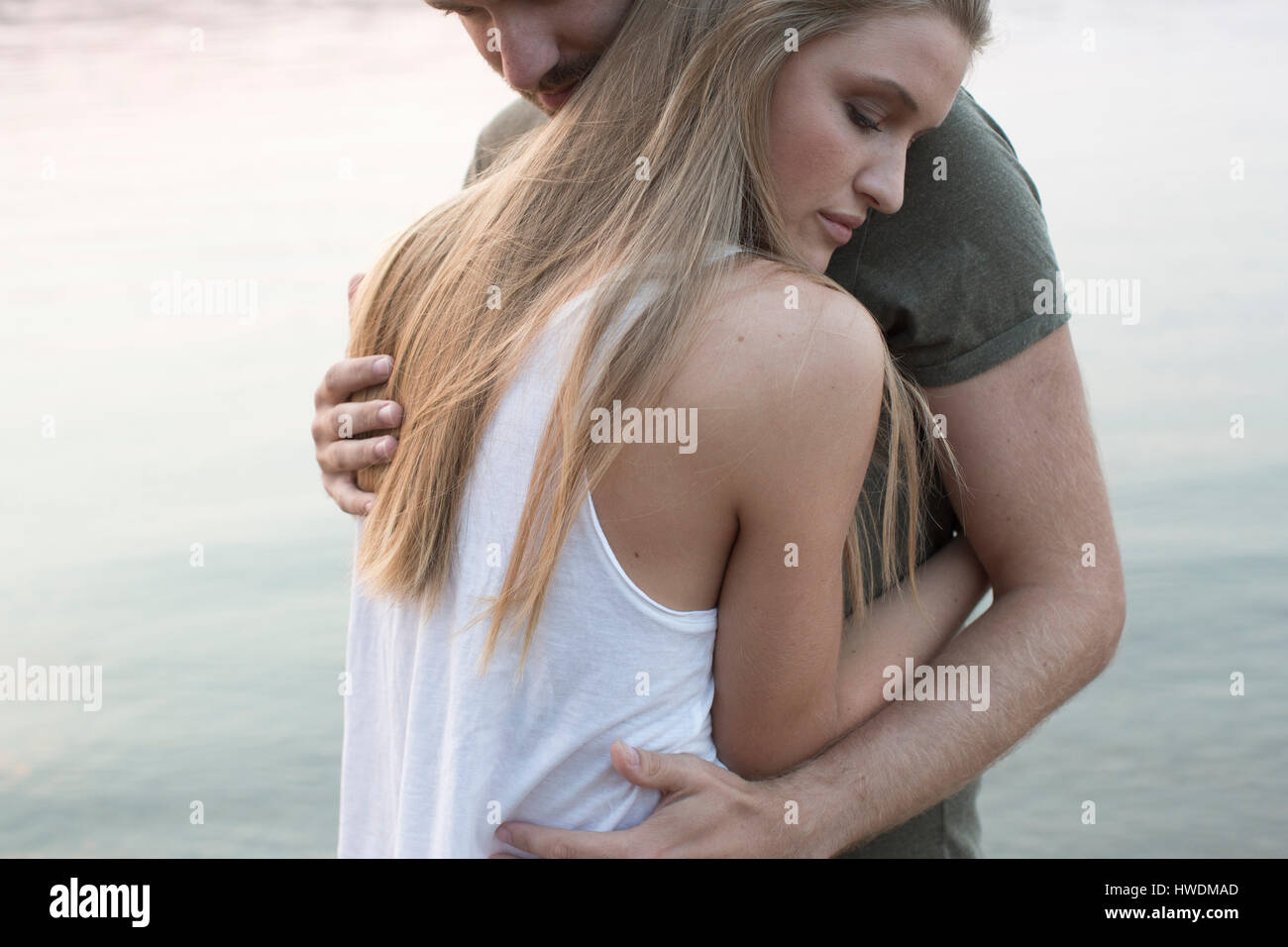 Couple hugging by river Stock Photo