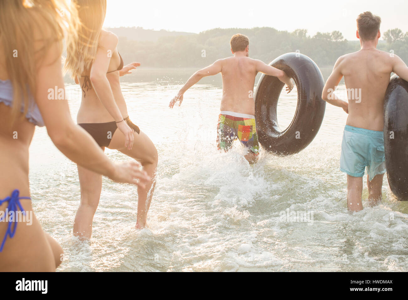 Friends having fun with inflatable ring in river Stock Photo