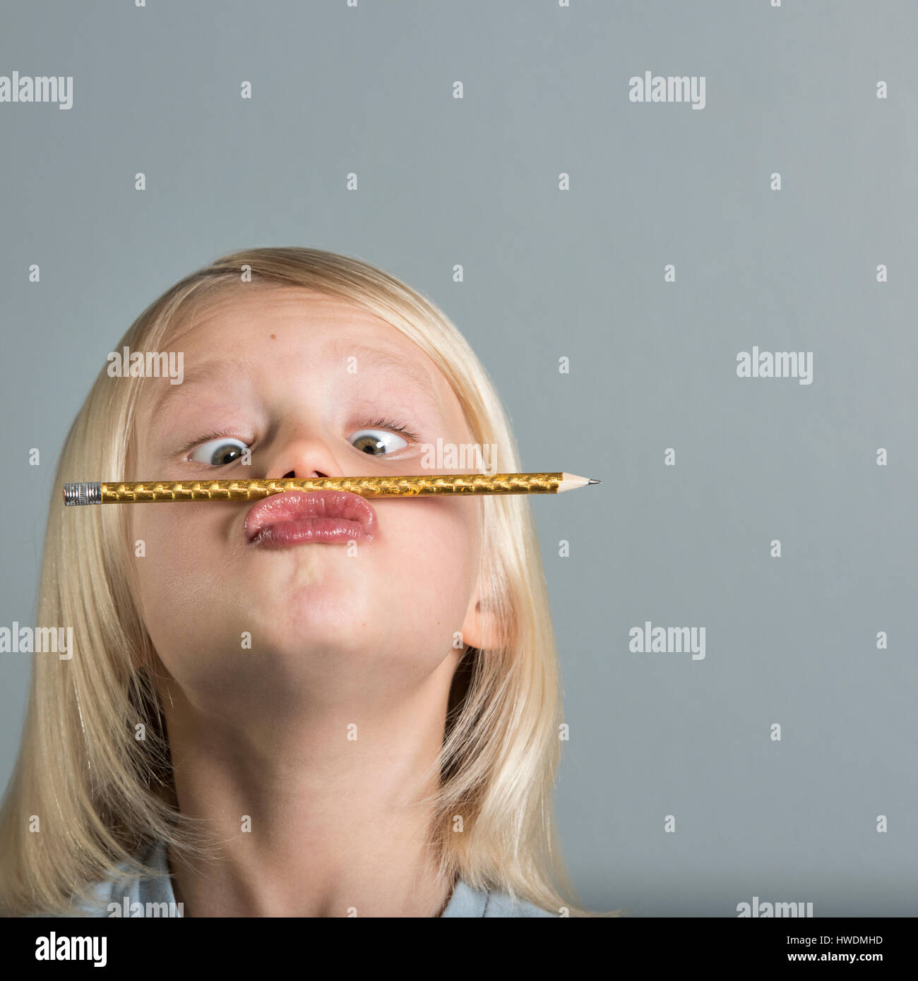 Portrait of boy balancing pencil on puckered lips Stock Photo