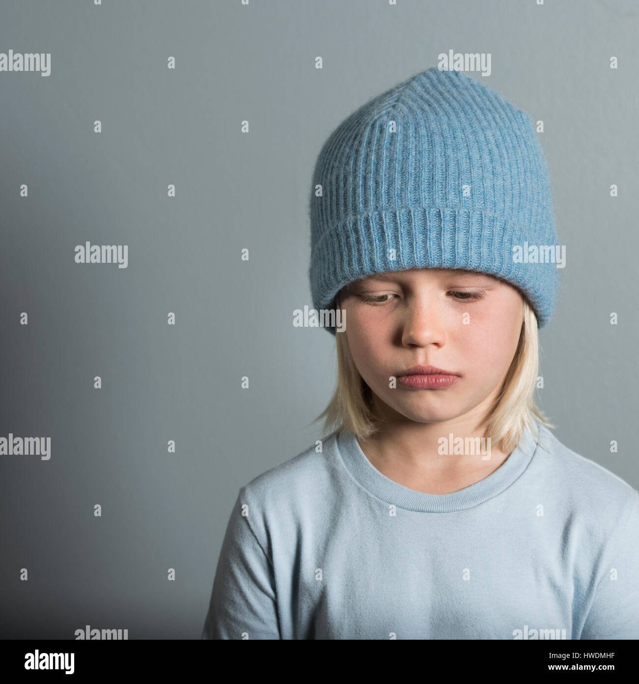 Portrait of boy wearing wool hat looking sad Stock Photo