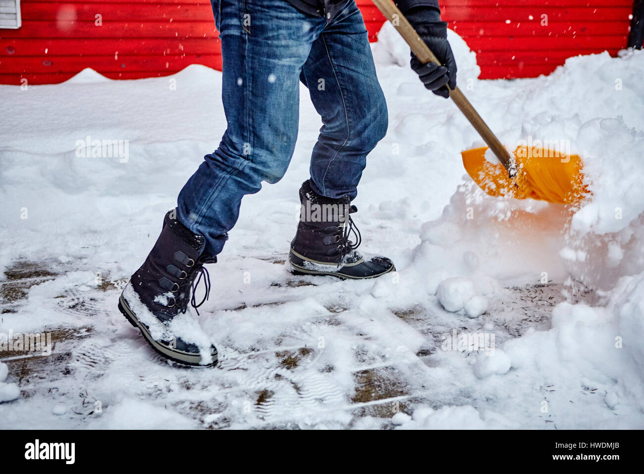 Man shovelling snow from pathway, low section Stock Photo