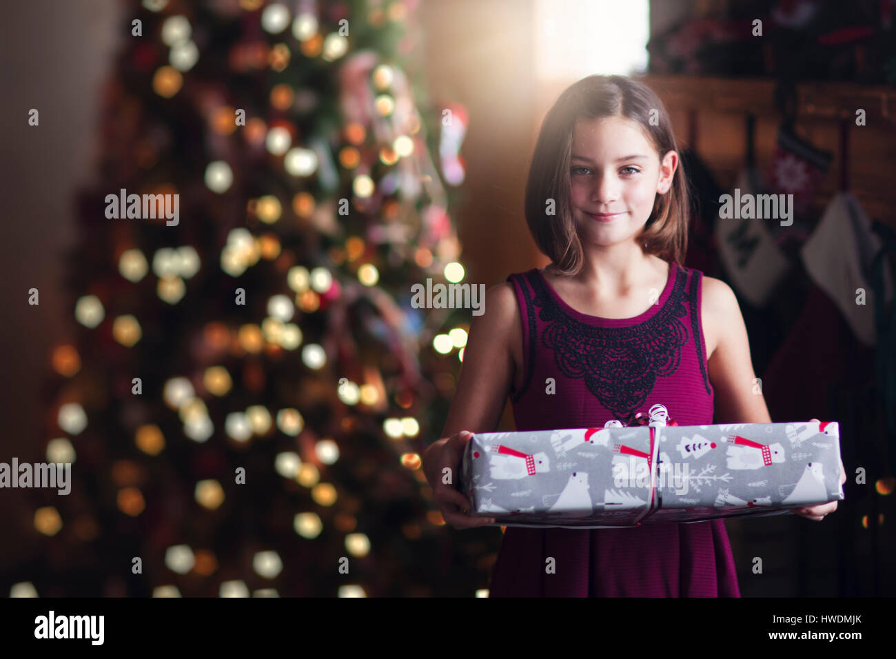 Young girl holding christmas gift Stock Photo - Alamy