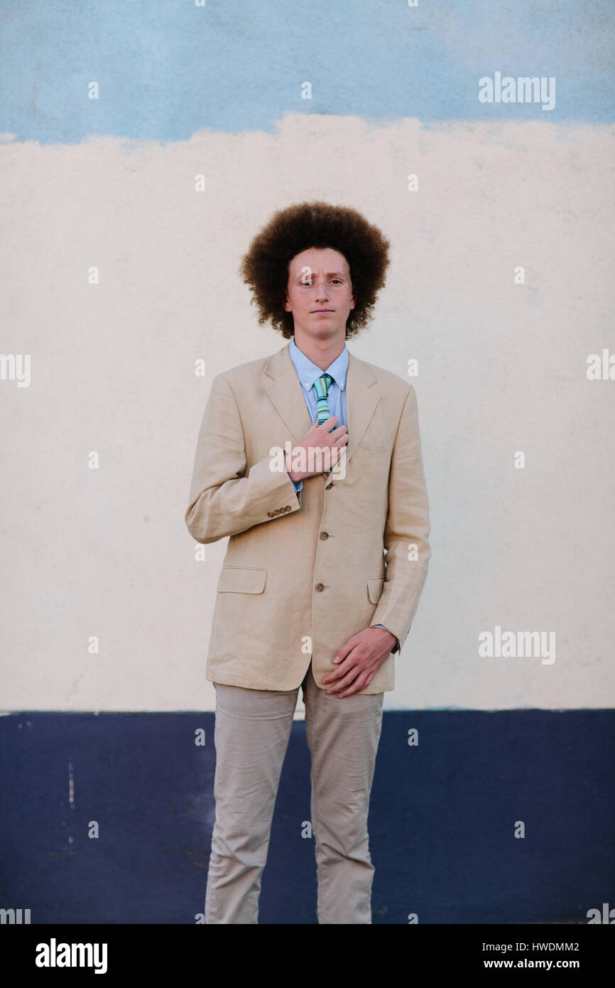 Portrait of teenage boy with red afro hair, wearing suit, outdoors Stock Photo