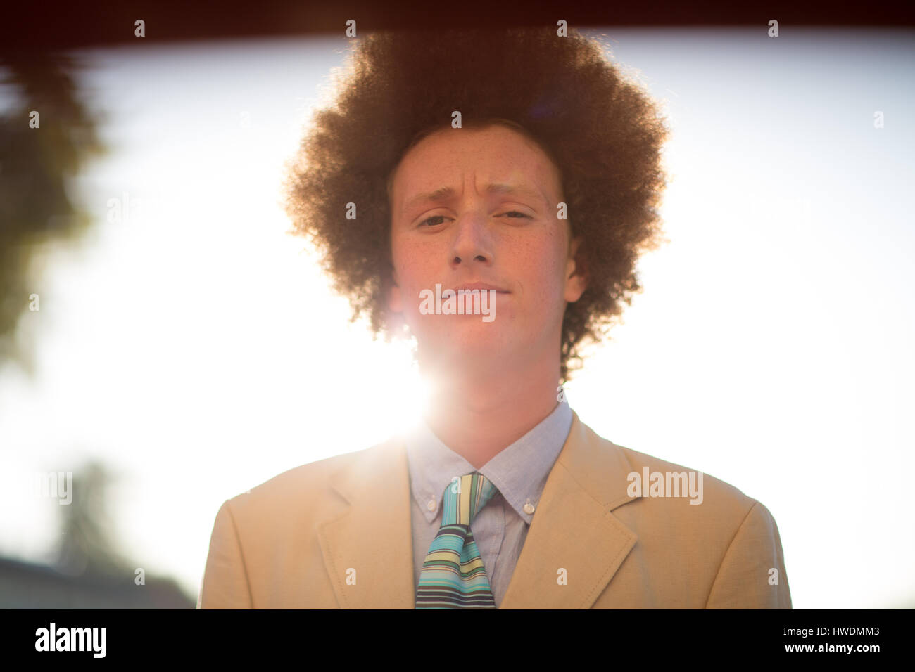 Portrait of teenage boy with red afro hair, wearing suit, outdoors Stock Photo
